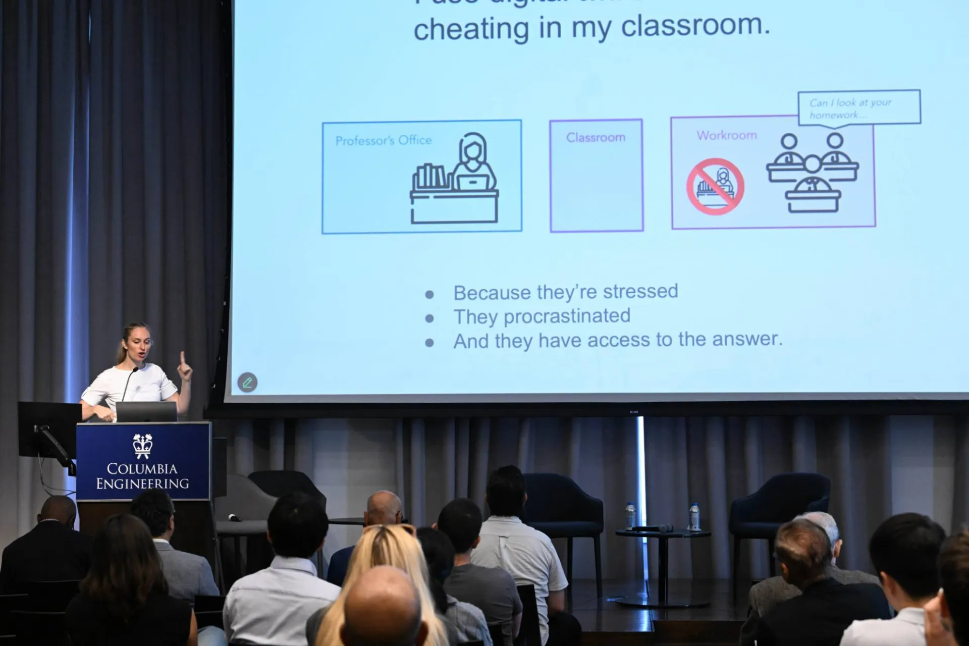 speaker at the podium, delivering presentation with a slide deck that reads "cheating in my classroom" with bullet points describing reasons why