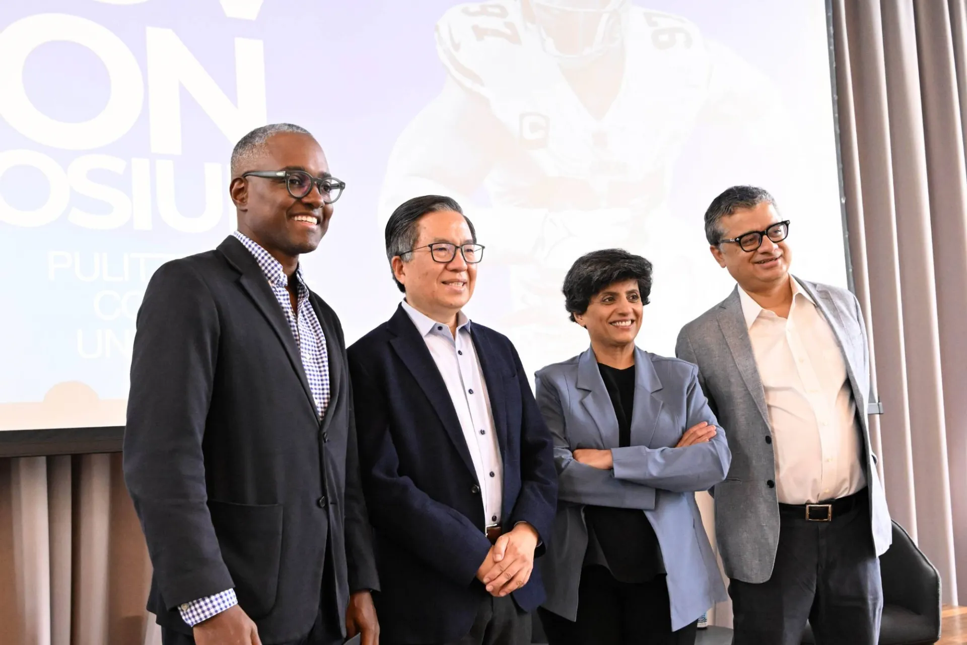 4 panelists smiling for a group photo in front of a "Sports AI Innovation Symposium" graphic 