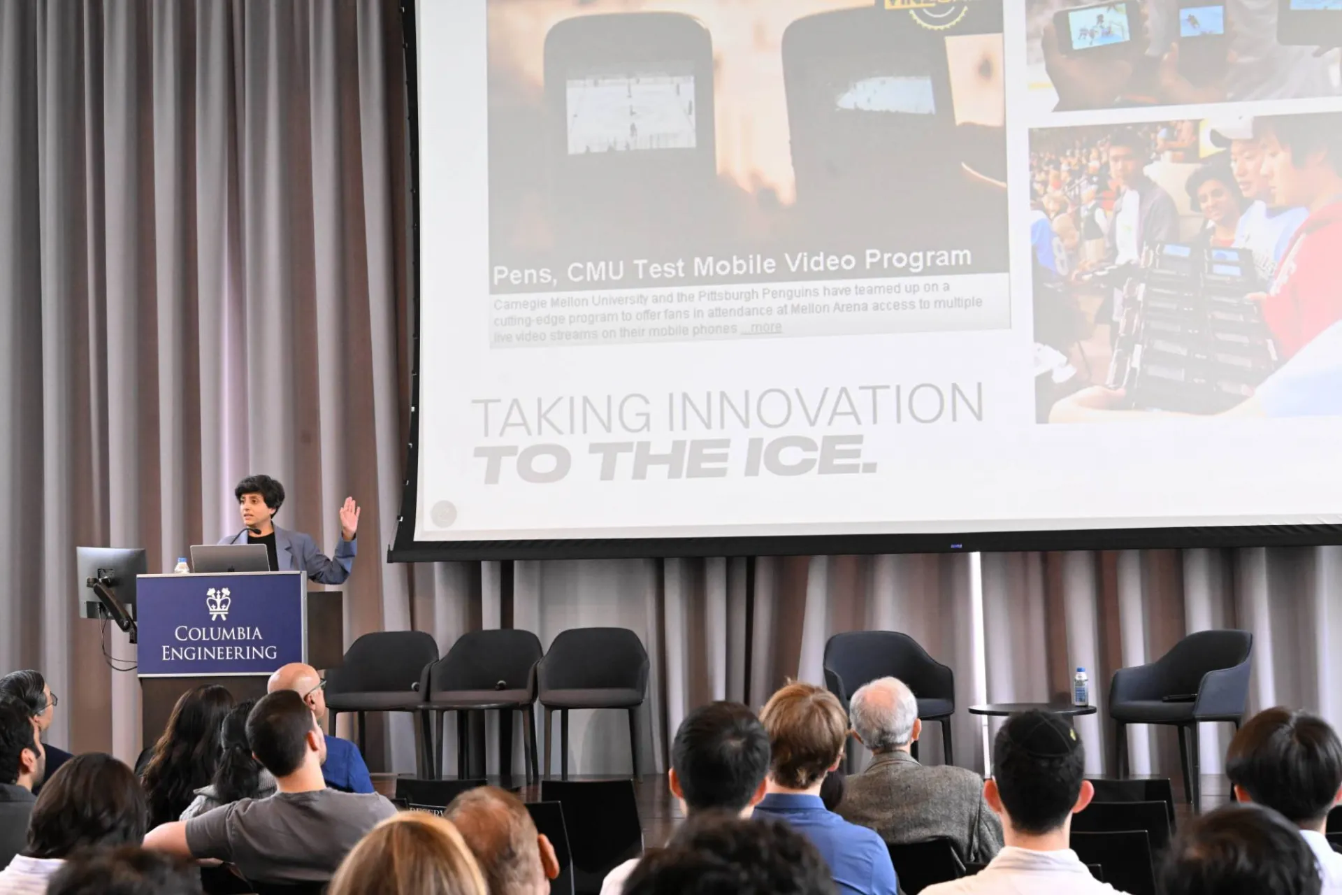 opening keynote speaker, Priya Narasimhan speaking at the podium while presenting slide deck that reads "taking innovation to the ice" with related imagery