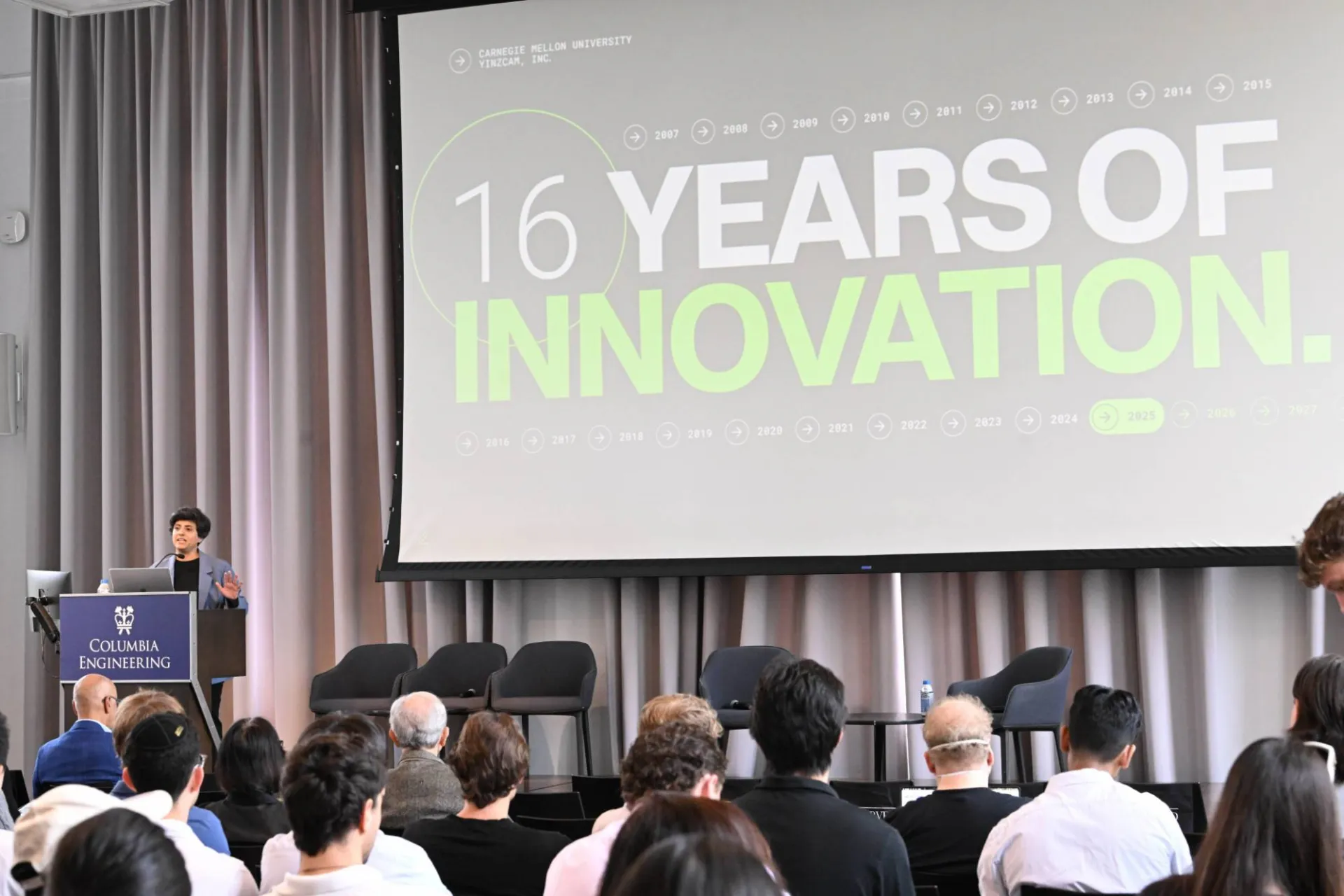 opening keynote speaker, Priya Narasimhan speaking at the podium while presenting slide deck that reads "16 years of innovation".